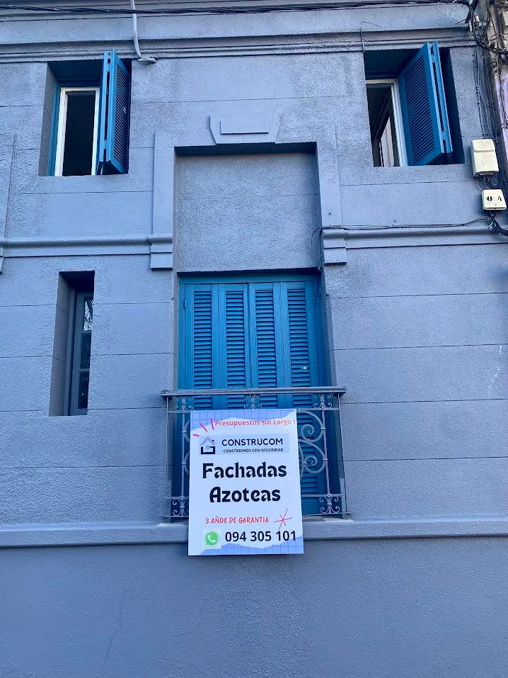 Fachada con obra de Construcom en curso, cartel de la empresa en el balcón